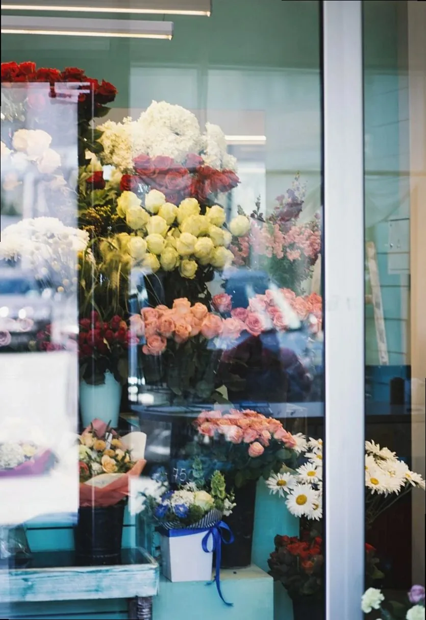 Colorful bouquet arrangements in a florist shop window showcasing a vibrant mix of flowers.